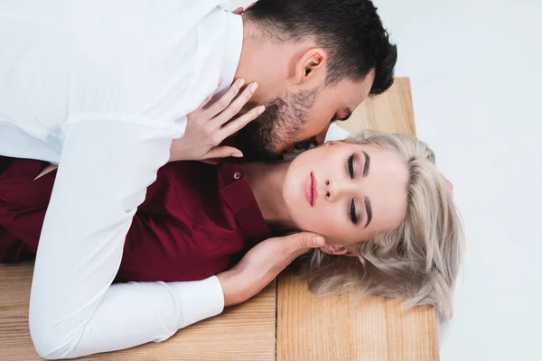 High angle view of businessman kissing young businesswoman on table at workplace — Stock Photo