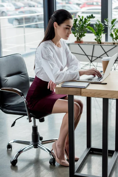 Bela jovem empresária usando laptop no local de trabalho — Fotografia de Stock