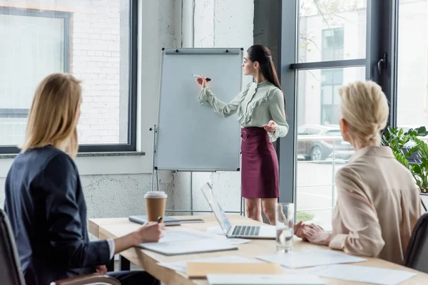 Femme d'affaires présentant le projet à ses collègues lors d'une réunion au bureau — Photo de stock