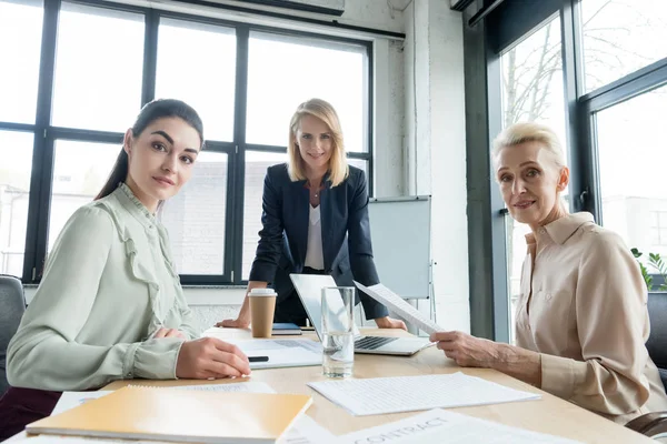 Beautiful businesswomen looking at camera at meeting in office — Stock Photo