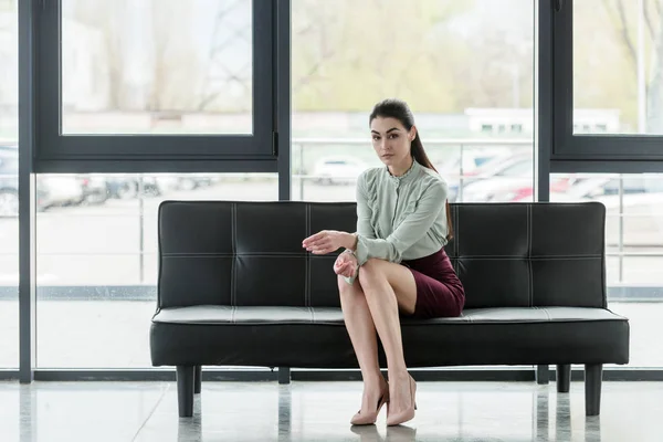 Attraktive Geschäftsfrau sitzt auf Sofa im Büro — Stockfoto