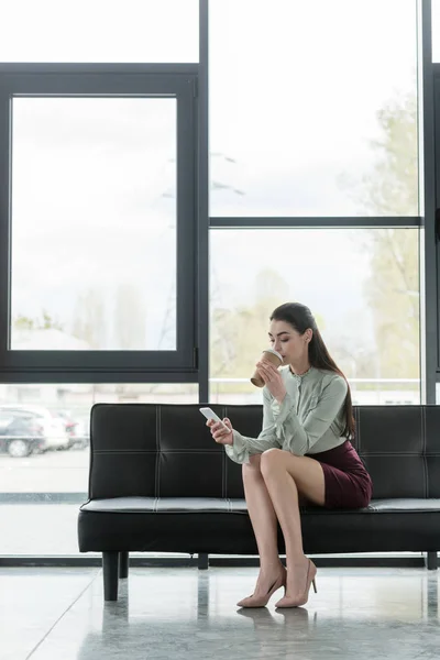 Belle femme d'affaires tenant smartphone et boire du café pour aller au bureau — Photo de stock