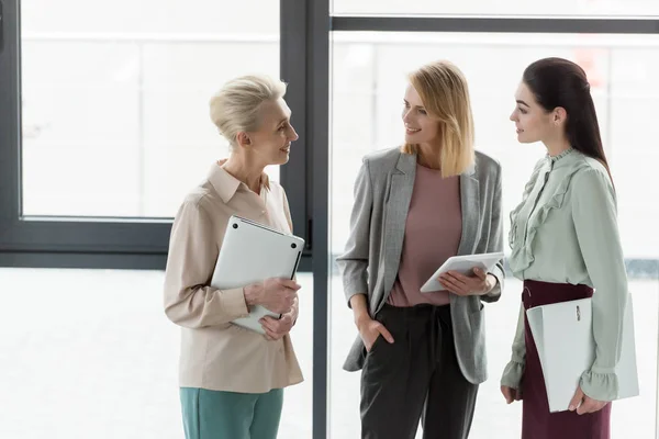 Souriant belles femmes d'affaires parlant au bureau — Photo de stock