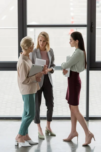 Tres mujeres de negocios profesionales hablando en el cargo - foto de stock