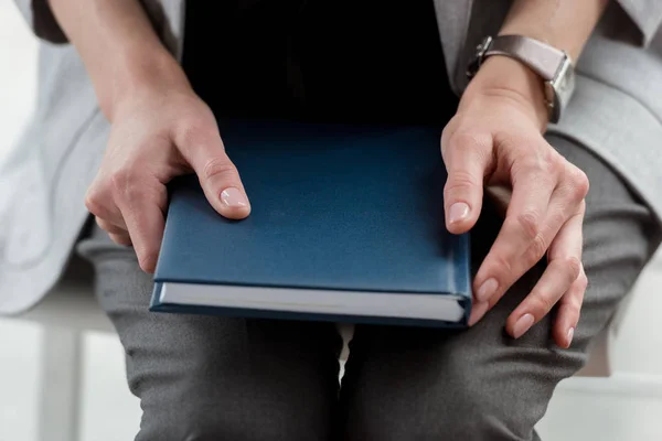 Abgeschnittenes Bild einer Geschäftsfrau mit Notizbuch im Büro — Stockfoto