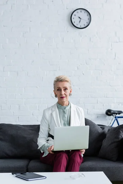 Stylish senior businesswoman using laptop in modern office — Stock Photo