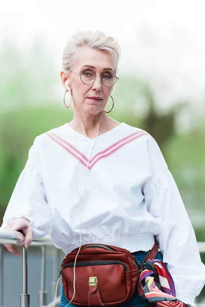 Mulher sênior elegante ouvir música com fones de ouvido — Fotografia de Stock