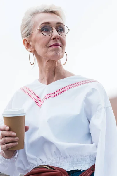 Atractiva mujer mayor en traje de moda con café para llevar - foto de stock