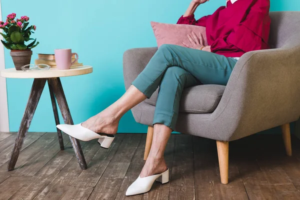 Abgeschnittene Ansicht einer eleganten Frau im Sessel mit Kissen — Stockfoto