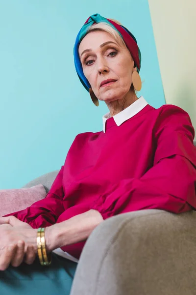 Elegante mujer mayor en estilo retro sentado en sillón - foto de stock