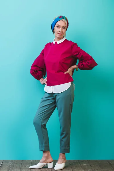 Mulher sênior na moda posando no quarto com parede turquesa — Fotografia de Stock