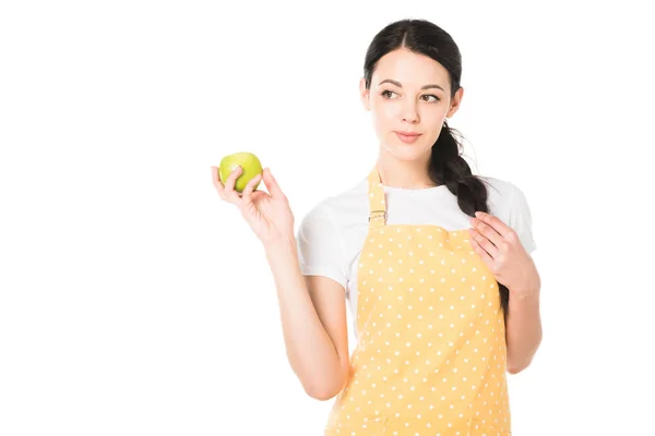 Приваблива жінка в фартусі тримає яблуко в руці ізольовано на білому тлі — стокове фото