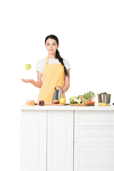 Junge Frau wirft Apfel auf Tischplatte mit Obst und Gemüse isoliert auf weißem Hintergrund — Stockfoto