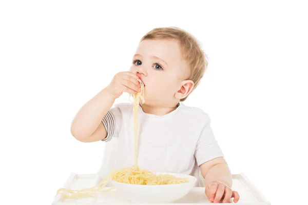 Little boy in highchair eating spaghetti by hand isolated on white background — Stock Photo