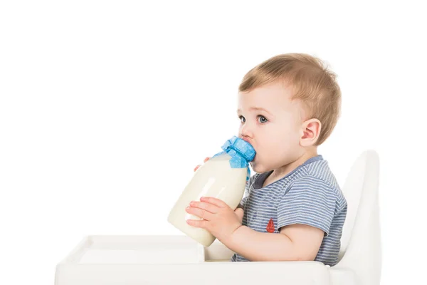 Bebé niño con biberón de leche y trona sentada aislada sobre fondo blanco - foto de stock