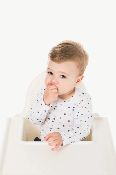 Vista de ángulo alto de comer bebé niño sentado en trona aislado sobre fondo blanco - foto de stock
