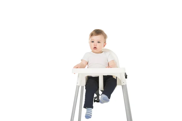 Baby boy in bib sitting in highchair isolated on white background — Stock Photo