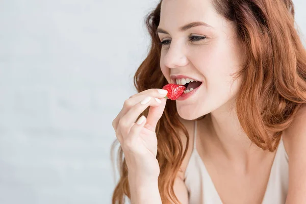 Retrato de cerca de la hermosa mujer joven comiendo fresa - foto de stock