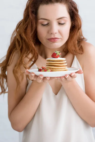 Sensual young woman with delicious pancakes on plate — Stock Photo