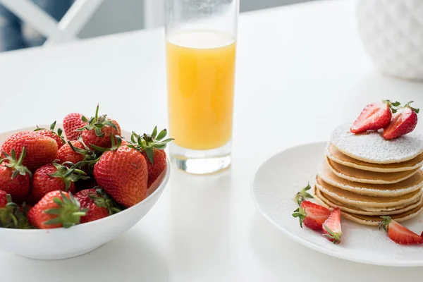Nahaufnahme von leckeren Pfannkuchen mit Erdbeeren und Orangensaft — Stockfoto