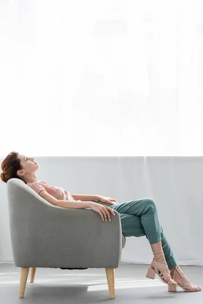 Attraente giovane donna rilassante su comoda poltrona a casa — Foto stock
