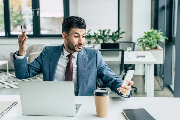 Emotional businessman gesturing during video call on smartphone — Stock Photo