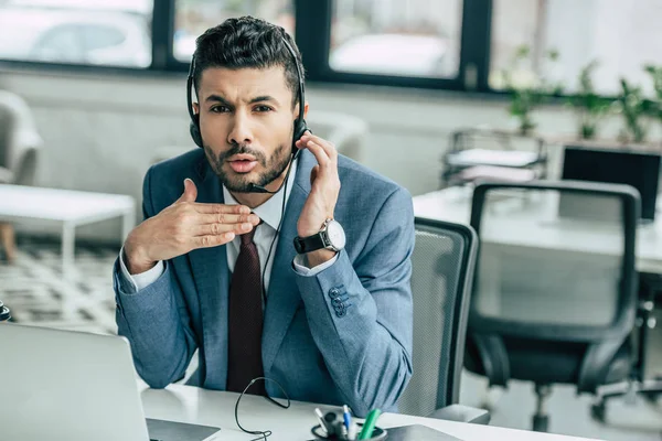 Displeased call center operator in headset showing stop gesture — Stock Photo
