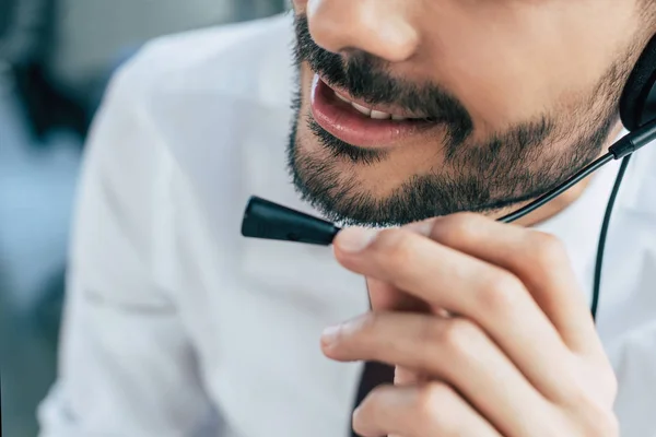 Partial view of call center operator smiling while using headset — Stock Photo