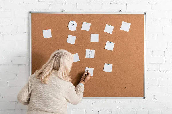 Vista posteriore di donna in pensione con malattia di Alzheimer scrittura su carta vicino a bordo — Foto stock