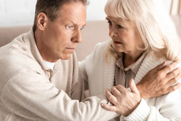 Homem idoso com doença de alzheimer sentado perto da esposa preocupada — Fotografia de Stock