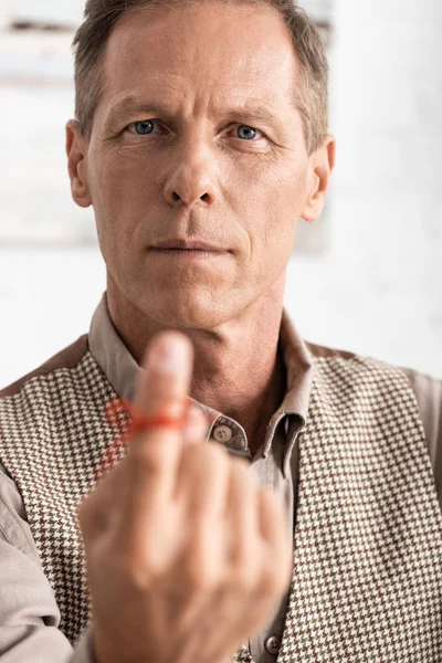 Selective focus of retired man with alzheimers disease string human finger reminder — Stock Photo