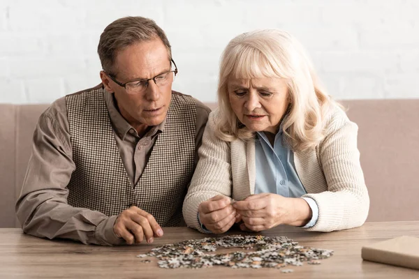 Selective focus of senior couple with mental illness matching puzzle pieces — Stock Photo