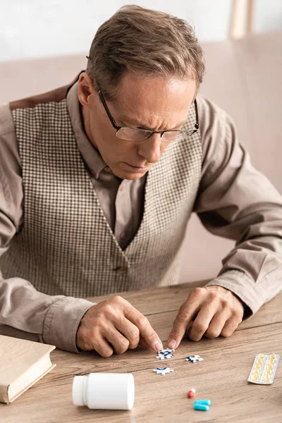 Selective focus of man with alzheimer touching jigsaw with question mark — Stock Photo