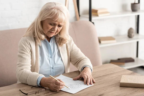 Seniorin mit psychischer Erkrankung zeichnet auf Papier — Stockfoto