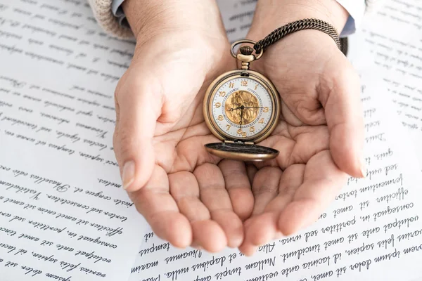 Vista dall'alto della donna anziana che tiene orologio da tasca vicino a carte con lettere — Foto stock