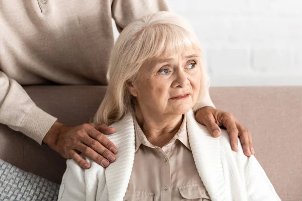 Vista recortada del hombre retirado de pie cerca de la esposa enferma - foto de stock