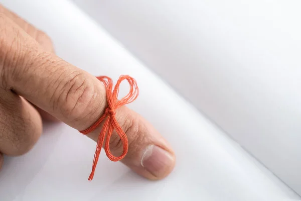 Cropped view of senior man with alzheimers disease string human finger reminder near notebook — Stock Photo