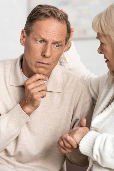 Retired man with mental illness holding hand with sad wife — Stock Photo