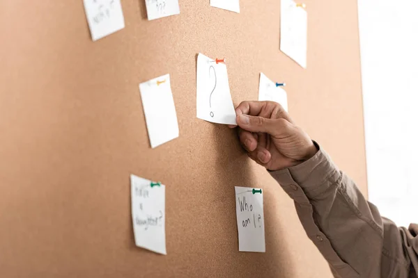 Cropped view of retired man touching paper with question mark on board — Stock Photo