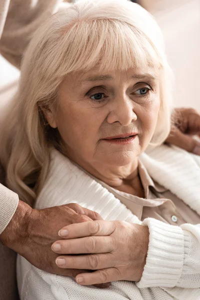 Cropped view of senior man holding hands with sick wife at home — Stock Photo