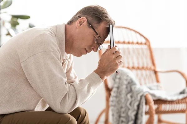 Sick retired man in glasses holding notebook — Stock Photo
