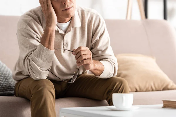 Vue recadrée d'un aîné malade assis sur un canapé — Photo de stock