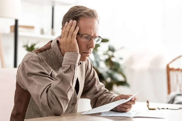 Senior man with dyslexia holding paper while reading at home — Stock Photo