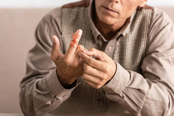 Обрезанный взгляд пенсионера с болезнью Альцгеймера струны человеческого пальца напоминание — стоковое фото