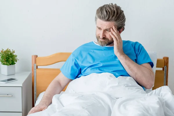 Bel paziente in abito medico con mal di testa in ospedale — Foto stock