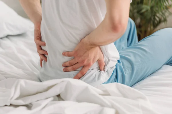 Abgeschnittene Ansicht eines Mannes, der Lendenschurz berührt, während er unter Schmerzen leidet — Stockfoto