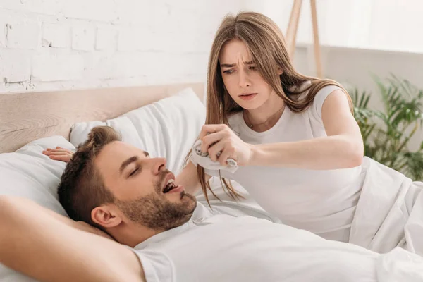 Dissatisfied woman holding hanky near face of snoring husband — Stock Photo