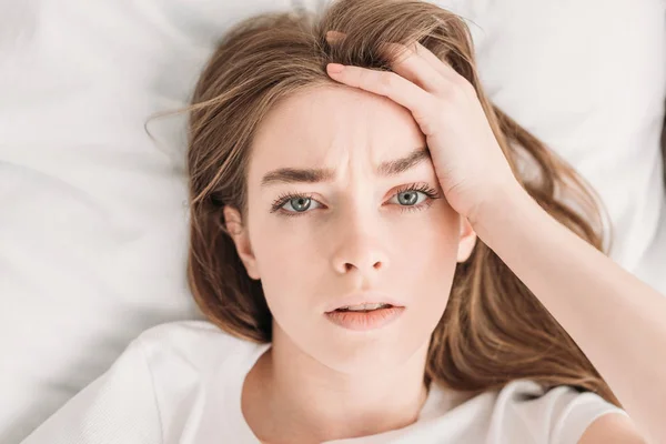 Top view of young woman looking at camera while suffering from headache — Stock Photo