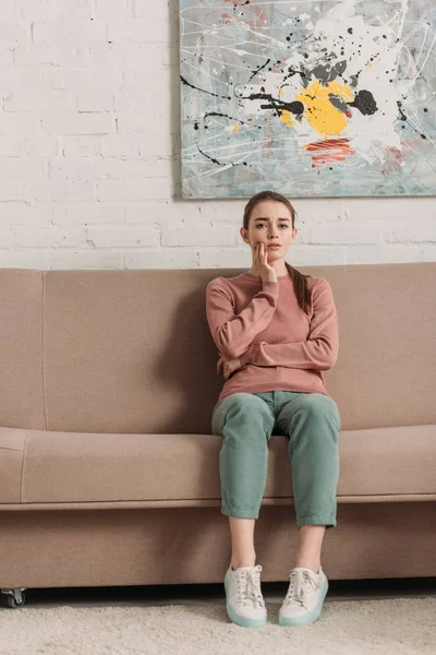 Upset girl looking at camera while suffering from toothache — Stock Photo