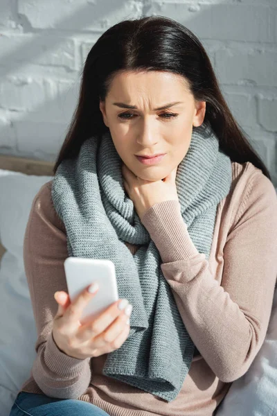 Хвора жінка має онлайн-консультацію з лікарем на смартфоні — стокове фото